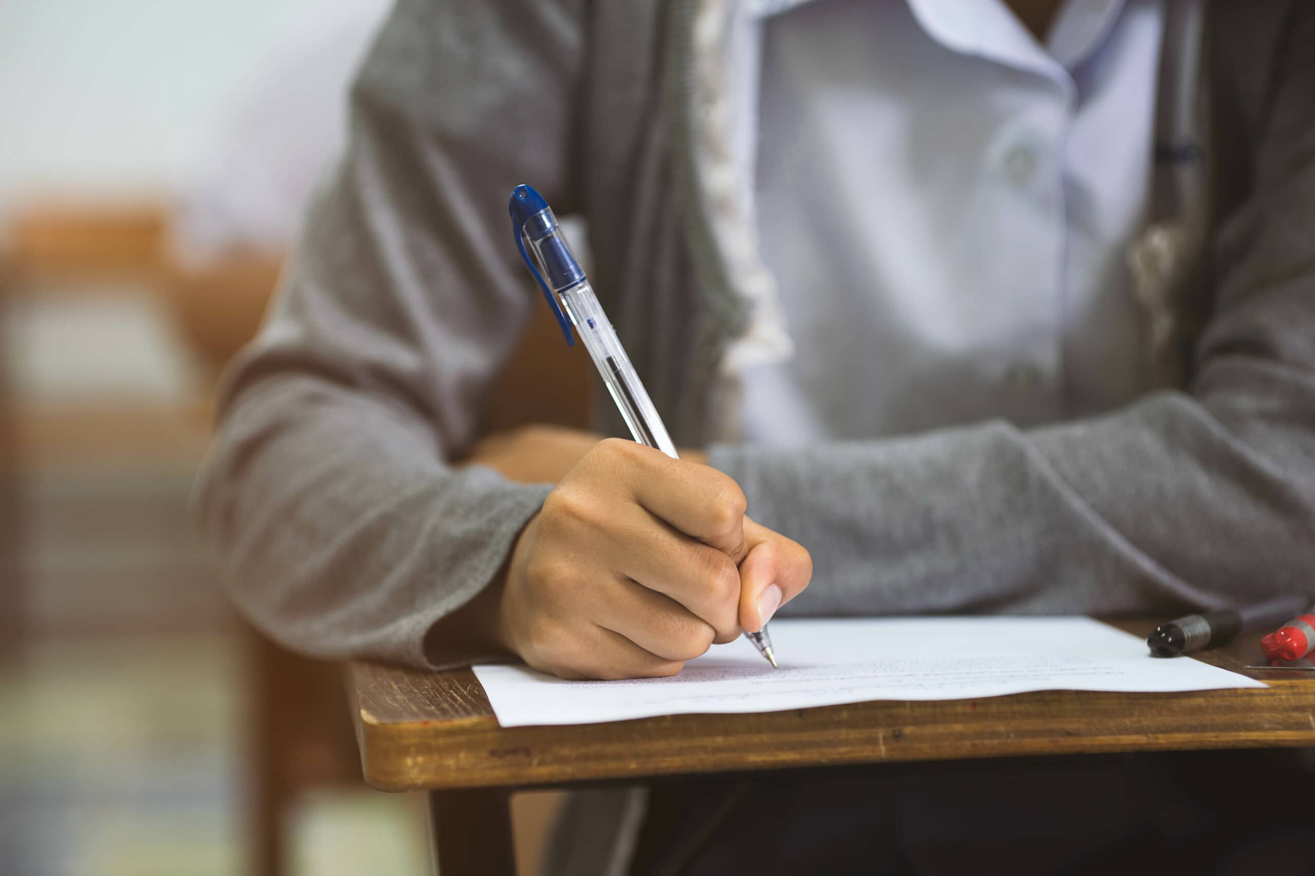 Close up hand of student writing in an exam.