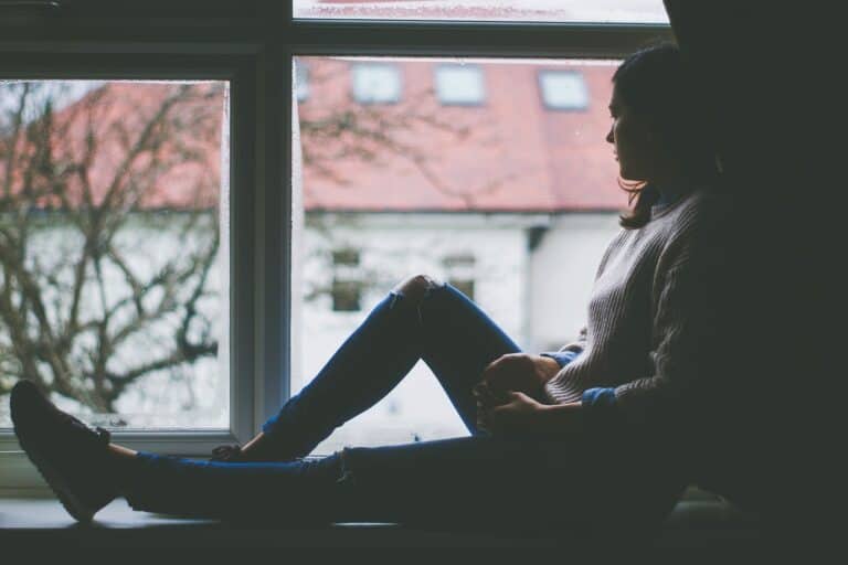 An woman looking forlornly out a window