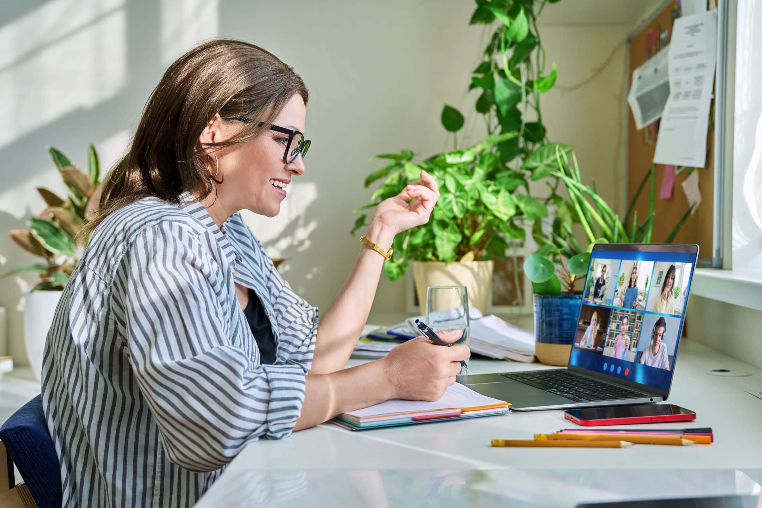 Supportive woman engaging in virtual meeting at work, attending an online video conference from home.